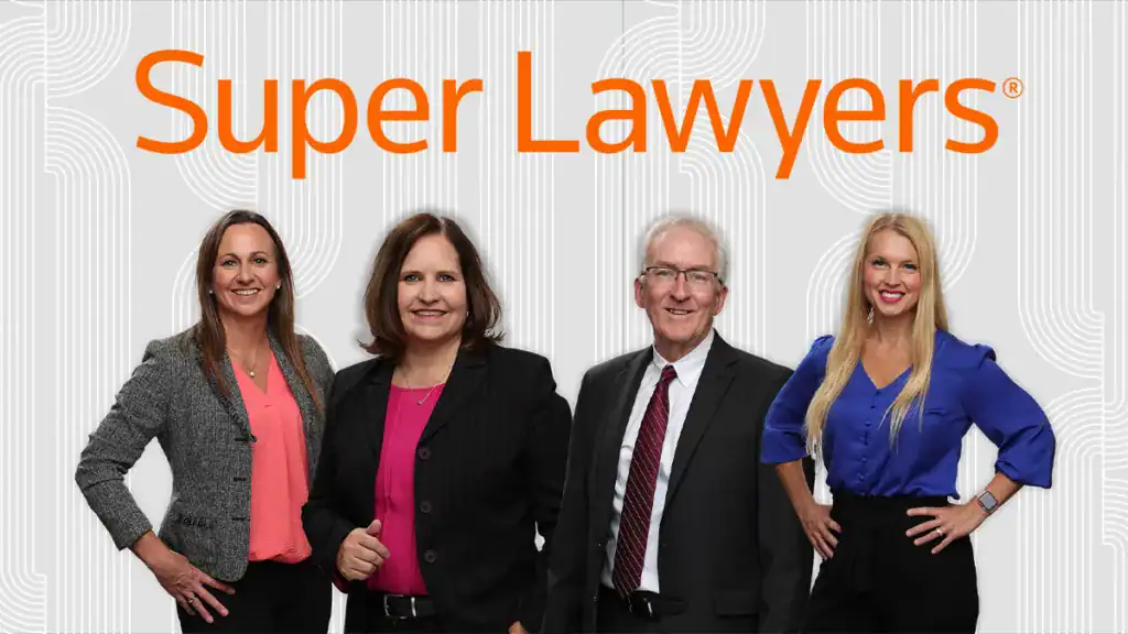 Diverse team of legal professionals standing together smiling, dressed in business attire, representing excellence in the legal field.